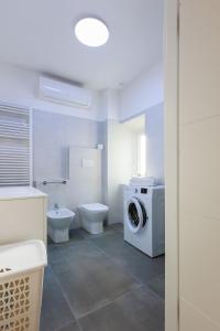 a bathroom with a toilet and a washing machine at Casa Germana, Marano Ticino in Marano Ticino