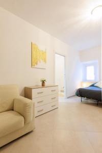 a bedroom with a bed and a couch and a dresser at Casa Germana, Marano Ticino in Marano Ticino