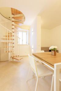 a dining room with a wooden table and white chairs at Casa Germana, Marano Ticino in Marano Ticino