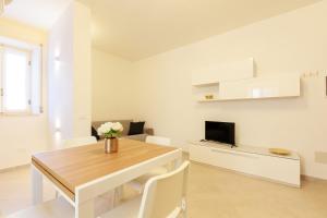 a white living room with a table and a tv at Casa Germana, Marano Ticino in Marano Ticino