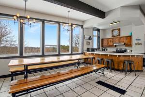 a large kitchen with a wooden bench in the middle at Northview-Blue Mountain-Sauna-Firepit-Balcony-Parking in Blue Mountains