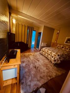 a bedroom with a bed and a desk and a television at Pousada Chateau Bella Vista in Campos do Jordão