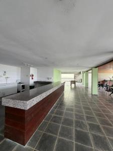 a large room with a counter in the middle at Flat Vila Monte Castelo in Gravatá