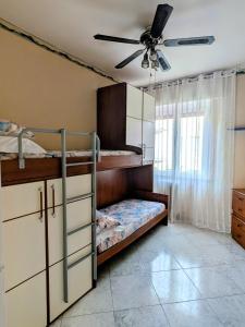 a bedroom with bunk beds and a ceiling fan at In Via Capri 1991 APARTMENT in Follonica