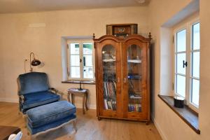 a living room with a grandfather clock and a chair at Country Villa with Heated Pool & Private Sauna, close to South Styrian Wine Road in Kamnica