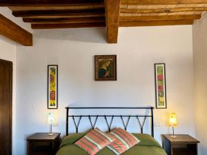 a bedroom with a bed with two night stands and two lamps at Cor Magis in San Quirico dʼOrcia