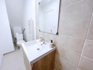 a bathroom with a sink and a mirror and a toilet at Le Duc 1 - Appartement 2 pers - Centre Ville in Valence +7 photos