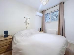 a white bedroom with a bed and a window at Le Duc 1 - Appartement 2 pers - Centre Ville in Valence