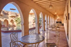 a patio with a table and chairs in a building at kasbah boutique mamouche in Adrouine