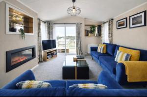 a living room with a blue couch and a fireplace at The View Point Northumberland in Newton on the Moor