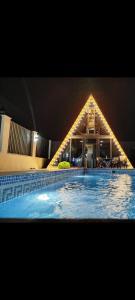 a large swimming pool with a house in the background at Emaar Afreem Pastar Qebele in Gabala