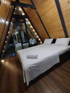 a bedroom with a large white bed in a attic at Emaar Afreem Pastar Qebele in Gabala