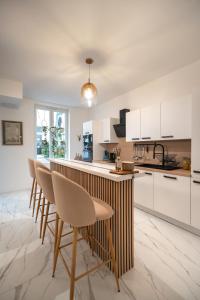 a kitchen with white cabinets and a bar with stools at Vandenbranden Suites in Brussels