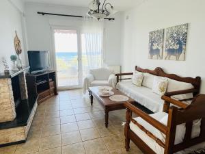 a living room with a couch and a fireplace at Villa Di Costa in Nea Skioni