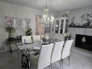 a dining room table with white chairs and a chandelier at vacation paradise in Ararat