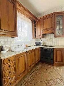 a kitchen with wooden cabinets and a sink and a stove at Villa Di Costa in Nea Skioni