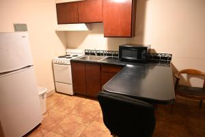 a small kitchen with a stove and a refrigerator at Airport Motel in Pasco +2 photos
