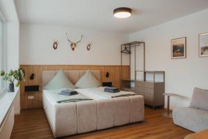 a bedroom with a large bed and a chair at Schwarzwald Loft Bergblick in St. Blasien