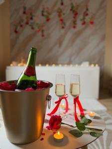 a bottle of champagne in a bucket on a table with glasses at Lindomptable love room in Méricourt