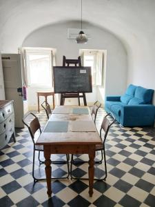 a living room with a table and a blue couch at Cosmogama House in Évora