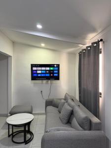 a living room with a couch and a tv on the wall at Island Ease Villa in Willemstad