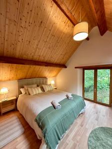 a bedroom with a large bed with a wooden ceiling at Bergerie GOICOLEA in Viscos