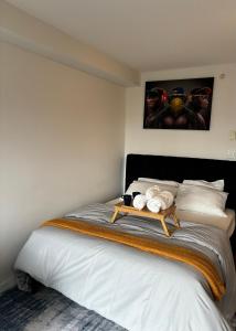 a bedroom with a bed with a table on it at Executive 2 beds and 1 bath suit in Surrey