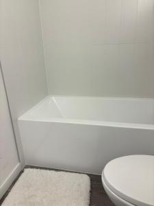 a bathroom with a white toilet and a rug at Executive 2 beds and 1 bath suit in Surrey +14 photos