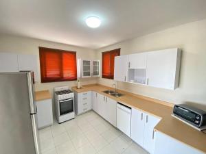 a kitchen with white cabinets and white appliances at Aruba Villa on a Hill in Savaneta
