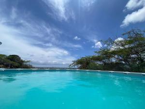 a large pool of blue water under a blue sky at Aruba Villa on a Hill in Savaneta