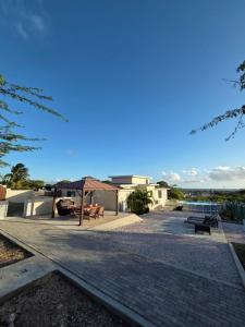 a brick walkway with a pavilion and a building at Aruba Villa on a Hill in Savaneta