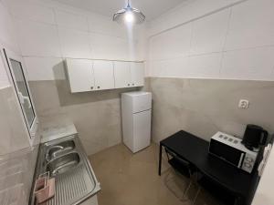 a small kitchen with a sink and a refrigerator at Sfiggos 54 Guest House in Athens