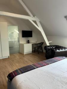a room with a bed and a couch and a television at B&B Bodegem in Dilbeek