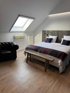 a bedroom with a large bed and a skylight at B&B Bodegem in Dilbeek +11 photos