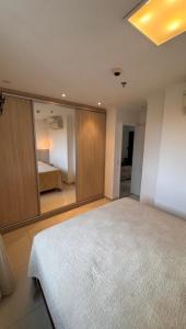 a bedroom with a large bed with a large mirror at Metropolitan Mall in Goiânia