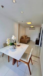 a living room with a white table and a couch at Metropolitan Mall in Goiânia
