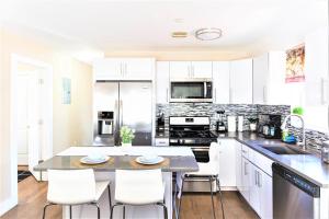 a kitchen with white cabinets and a table and chairs at Tonel Paradise in Rosedale