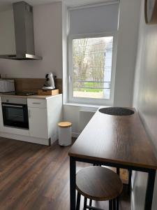 a kitchen with a wooden table and a window at Lindomptable love room in Méricourt