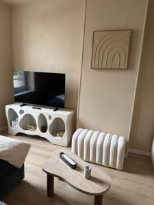 a living room with a white radiator and a table at Lindomptable love room in Méricourt