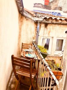 a balcony with a table and chairs on a balcony at Casa Soleya - Arènes de Nîmes - Au cœur de la cité Romaine in Nîmes