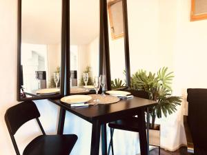 a dining room with a table and a mirror at Casa Soleya - Arènes de Nîmes - Au cœur de la cité Romaine in Nîmes