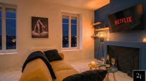 a living room with a couch and a fireplace at LE 21 - Suite SPA Premium - Jacuzzi Privatif & Vue Rhône in Vienne