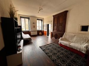 a living room with a couch and a tv at Le Rosier in Lure