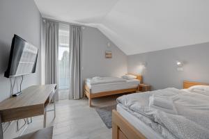 a hotel room with two beds and a television at House Degenia in Lovinac