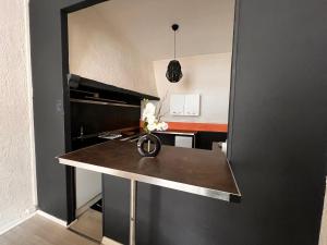 a kitchen with a table with a vase of flowers on it at Le Rosier in Lure +6 photos