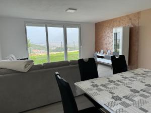 a living room with a couch and a table with chairs at Bela Bar in Pečurice