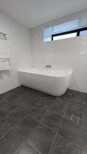 a white bath tub in a bathroom with a window at Cooma High Country Motel in Cooma