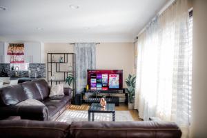 a living room with a couch and a tv at Tonel Paradise in Rosedale