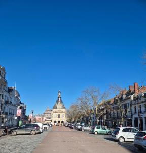 a city street with cars parked in front of a building at le St fursy 31 in Péronne