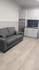 a living room with a couch and a kitchen at Cooma High Country Motel in Cooma
